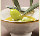 Pouring Olive Oil Over Olive Sprig with Green Olives